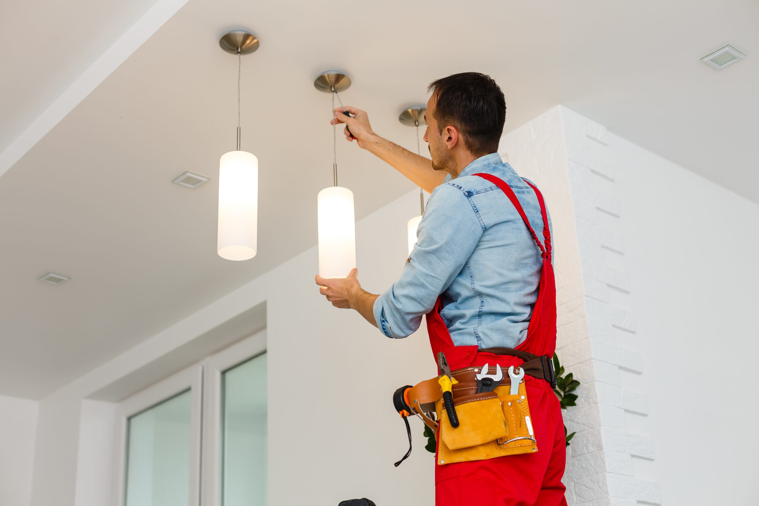 adjusting pendant light in a modern white room